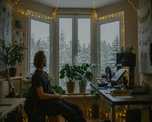Person stretching gently near a bright window in their home office